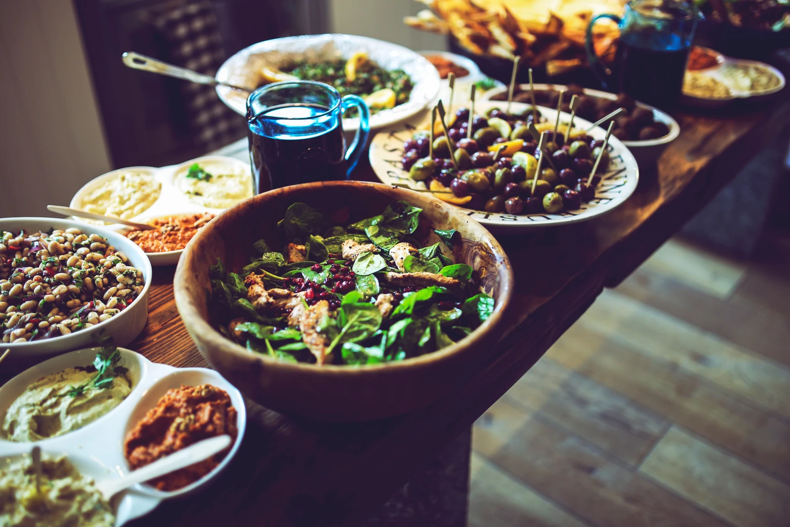 A shared table filled with salads, olives and colourful meze dishes